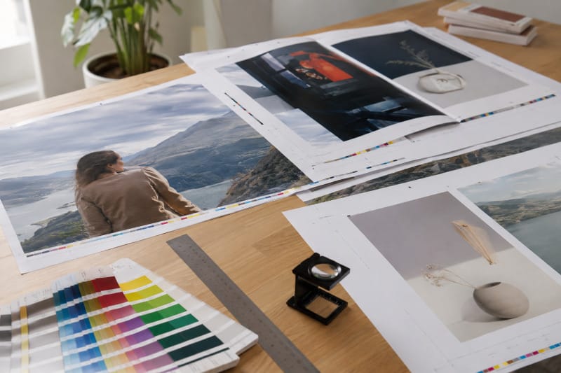 Pruebas impresas de una publicación con sangrado, marcas de corte y muestras de color preparadas para imprenta
