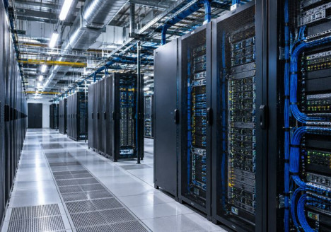 Pasillo de un centro de datos moderno con servidores y sistemas de refrigeración que sostienen los servicios de inteligencia artificial